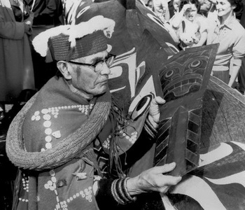 Mungo Martin displays his family copper at a totem pole raising ceremony